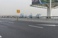 there is an empty road next to some lights and a billboard that looks like it has been taken over