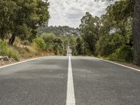 an empty road is shown in this undpicture image, with the trees surrounding it