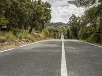 an empty road is shown in this undpicture image, with the trees surrounding it