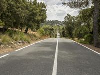 an empty road is shown in this undpicture image, with the trees surrounding it