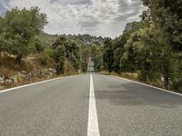 an empty road is shown in this undpicture image, with the trees surrounding it