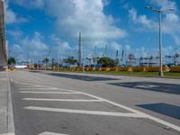 a empty empty road on a bright blue day with a view of a marina in the distance