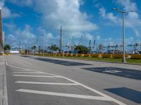 a empty empty road on a bright blue day with a view of a marina in the distance