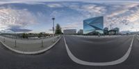 a view of an empty road near a modern building in a city setting with an upside down mirror