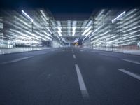 an empty road in a modern city at night with buildings and lamps on both sides