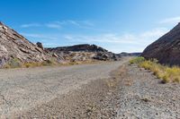 an empty road runs through the rocky mountainside landscape in the mojave desert, california