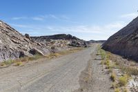 an empty road runs through the rocky mountainside landscape in the mojave desert, california