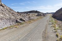 an empty road runs through the rocky mountainside landscape in the mojave desert, california