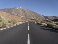 an empty road with a mountain in the distance with no vehicles in the distance, and the road not visible