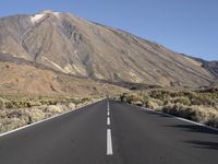 an empty road with a mountain in the distance with no vehicles in the distance, and the road not visible