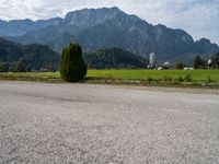 an empty road in front of some mountains with a mountain backdrop, and there is no traffic on the road