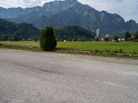 an empty road in front of some mountains with a mountain backdrop, and there is no traffic on the road