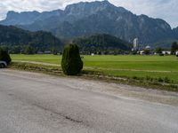 an empty road in front of some mountains with a mountain backdrop, and there is no traffic on the road