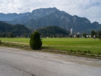 an empty road in front of some mountains with a mountain backdrop, and there is no traffic on the road