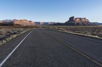 an empty empty road with mountains in the background and a sky with no clouds behind