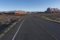 an empty empty road with mountains in the background and a sky with no clouds behind