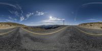 the empty road with mountains in the background is being distorted by an image of a sky