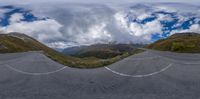 a 360 - ball panoramic photo of an empty road in the mountains on a cloudy day