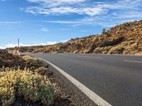 an empty road through the mountains in a desert scene is pictured on a clear day