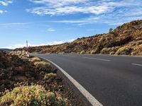 an empty road through the mountains in a desert scene is pictured on a clear day