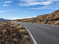 an empty road through the mountains in a desert scene is pictured on a clear day