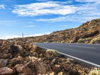 an empty road through the mountains in a desert scene is pictured on a clear day