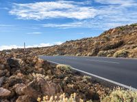 an empty road through the mountains in a desert scene is pictured on a clear day