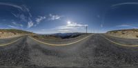 the empty road with mountains in the background is being distorted by an image of a sky