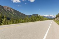 an empty road with mountains and pine trees in the background, in canada - stock image