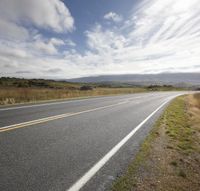 Empty Road: Embracing Nature on a Sunny Day with Clouds