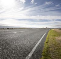 Empty Road: Embracing Nature on a Sunny Day with Clouds
