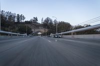 the back end of a car is driving down an empty road near a large archway