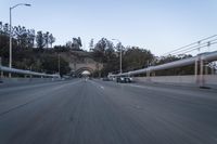 the back end of a car is driving down an empty road near a large archway