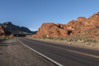 the road in the middle of the desert is empty and looks like it can be taken off the car