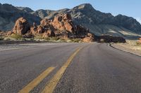 the road in the middle of the desert is empty and looks like it can be taken off the car