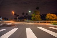 an image of an empty road at night time that is blurry, with the street lamp in the distance