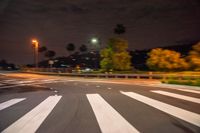 an image of an empty road at night time that is blurry, with the street lamp in the distance