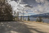 an empty road with a mountain and lake view in the distance at a scenic location