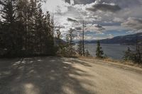 an empty road with a mountain and lake view in the distance at a scenic location