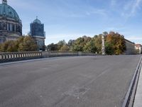 a street with an empty road and an old building in the background on a sunny day