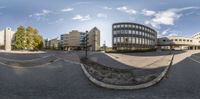 there are many buildings and the road is empty yet taken out in this image in spherical format