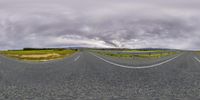 a panoramic image taken from an empty road and showing several lanes of the same width