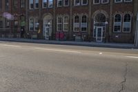 the stop sign is posted on an empty road with no vehicles parked in it while the sun shines behind
