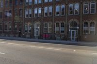 the stop sign is posted on an empty road with no vehicles parked in it while the sun shines behind