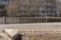 the road is empty and has rocks on it by a large rock next to a street