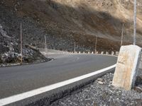 an empty road with rocky hills in the background and no one on it near by