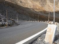 an empty road with rocky hills in the background and no one on it near by