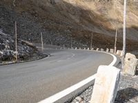 an empty road with rocky hills in the background and no one on it near by