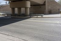 the shadow on the side of an empty road on a sunny day with no clouds