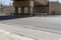 the shadow on the side of an empty road on a sunny day with no clouds